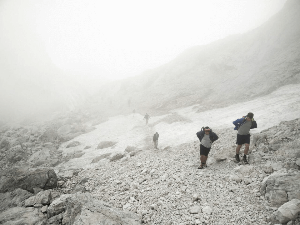 Das Bild zeigt die Reisegruppe beim Aufstieg auf den Berg Mangard in Slowenien, die von Nebel und Schnee überrascht wurde.